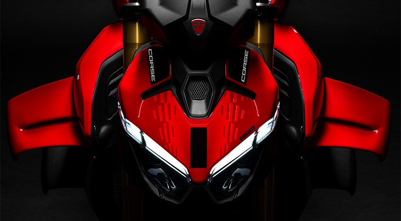 SF-V4-corse Vista frontal de los faros LED encendidos y los alerones aerodinámicos rojos de una Ducati Streetfighter V4.