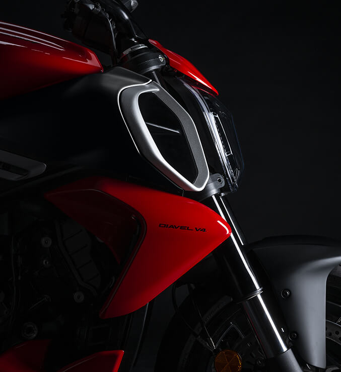 Detalle lateral frontal de Ducati Diavel V4 roja con acabados premium y diseño deportivo.